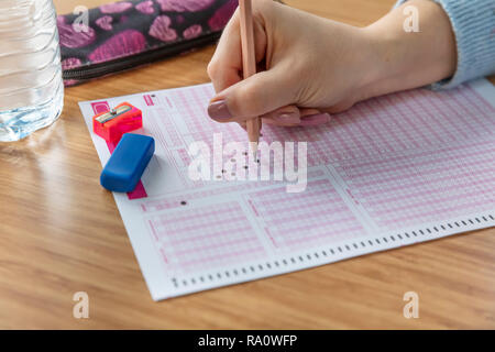 Pencil drawing selected choice on answer sheets. hand fill in Exam carbon paper computer sheet and pencil. Stock Photo