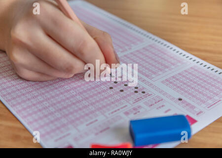 Pencil drawing selected choice on answer sheets. hand fill in Exam carbon paper computer sheet and pencil. Stock Photo