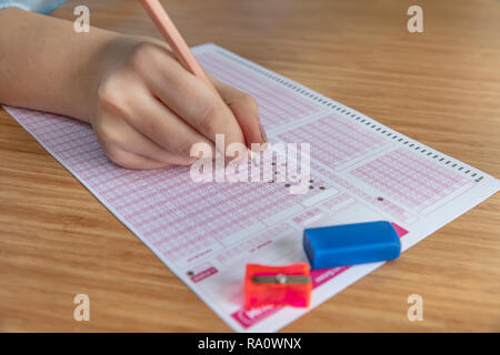 Pencil drawing selected choice on answer sheets. hand fill in Exam carbon paper computer sheet and pencil. Stock Photo