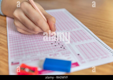 Pencil drawing selected choice on answer sheets. hand fill in Exam carbon paper computer sheet and pencil. Stock Photo