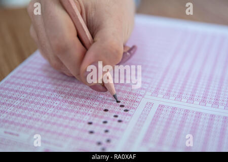 Pencil drawing selected choice on answer sheets. hand fill in Exam carbon paper computer sheet and pencil. Stock Photo
