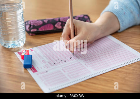 Pencil drawing selected choice on answer sheets. hand fill in Exam carbon paper computer sheet and pencil. Stock Photo
