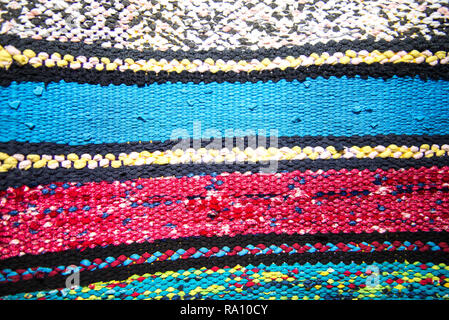 Texture of multi-colored homespun rug. Traditional rustic very long carpet with a striped pattern for use on a bench or floor Stock Photo
