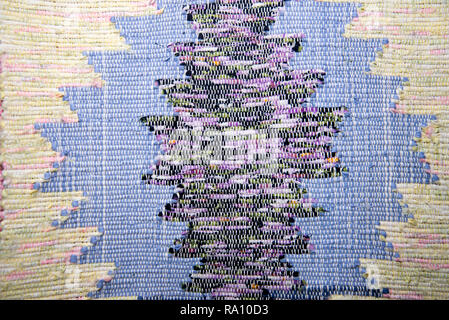 Texture of multi-colored homespun rug. Traditional rustic very long carpet with a striped pattern for use on a bench or floor Stock Photo