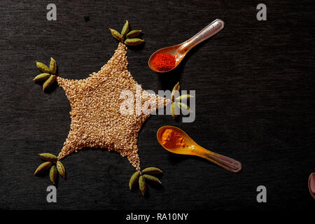spices in spoons on black background Stock Photo