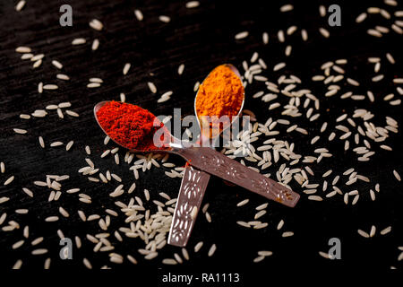 spices in spoons on black background Stock Photo