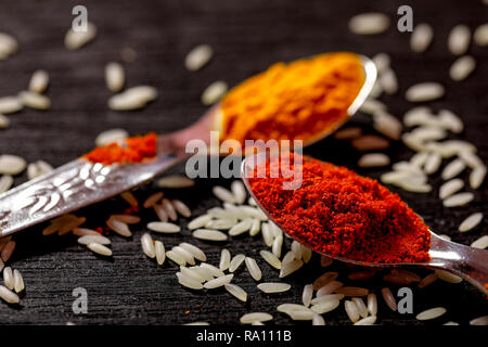 spices in spoons on black background Stock Photo