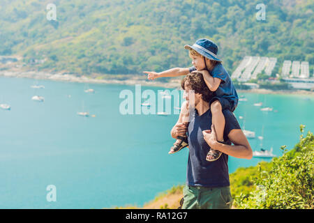 Father and son in the background of Promthep cape and Yanui beach. Phuket, Thailand. Traveling with children concept