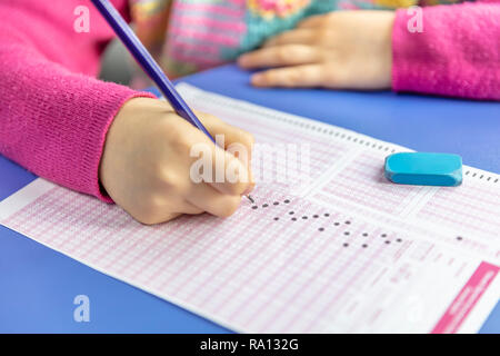 Pencil drawing selected choice on answer sheets. hand fill in Exam carbon paper computer sheet and pencil. Stock Photo