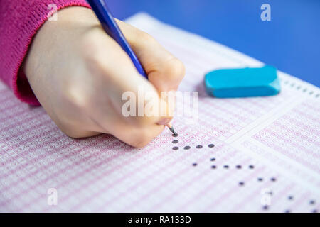 Pencil drawing selected choice on answer sheets. hand fill in Exam carbon paper computer sheet and pencil. Stock Photo
