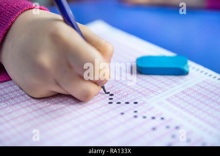 Pencil drawing selected choice on answer sheets. hand fill in Exam carbon paper computer sheet and pencil. Stock Photo