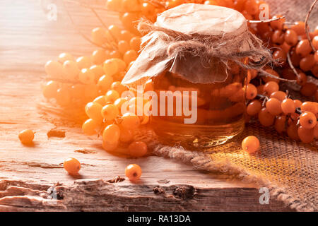 Sea buckthorn jam in bank on a wooden background Stock Photo