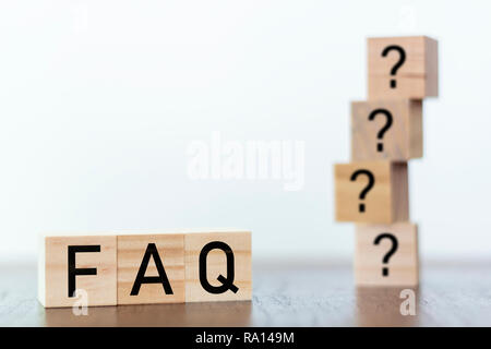 FAQ on wooden blocks with question marks on the background Stock Photo