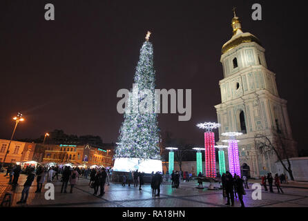 Kiev, Ukraine. 29th Dec, 2018. People seen next to the main Christmas tree of Ukraine, on the St. Sophia Square in Kiev, Ukraine.The main Christmas tree of Ukraine, was decorated in the northern lights style, it topped the rating of the most beautiful Christmas trees in Europe, according to the European Best Destinations website. The list included Christmas trees of 16 European. Credit: Pavlo Gonchar/SOPA Images/ZUMA Wire/Alamy Live News Stock Photo