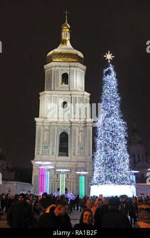 People seen next to the main Christmas tree of Ukraine, on the St. Sophia Square in Kiev, Ukraine. The main Christmas tree of Ukraine, was decorated in the northern lights style, it topped the rating of the most beautiful Christmas trees in Europe, according to the European Best Destinations website. The list included Christmas trees of 16 European. Stock Photo