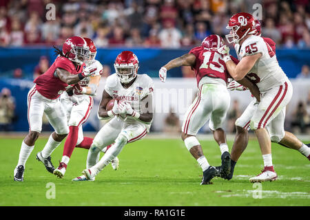 Florida, USA. 29th Dec, 2018. Oklahoma Sooners running back Trey Sermon (4) carries the ball for a 4 yard gain against the Alabama Crimson Tide during the second quarter in the 2018 Capital One Orange Bowl at Hard Rock Stadium on December 29, 2018 in Florida. Credit: Travis Pendergrass/ZUMA Wire/Alamy Live News Stock Photo