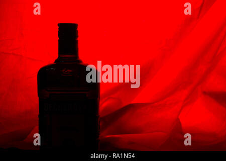 alcohol bottle on red backround. copy cpace Stock Photo