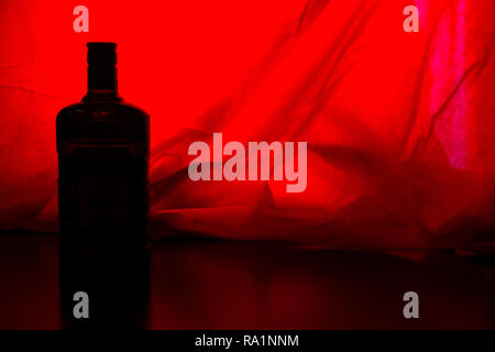 alcohol bottle on red backround. copy cpace Stock Photo