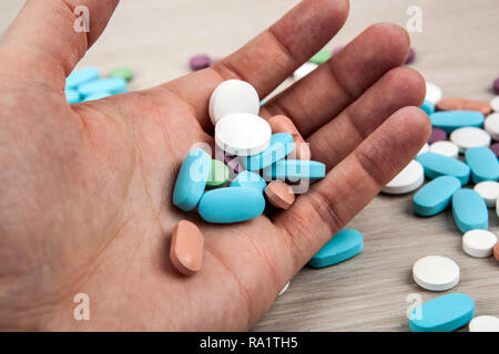 multi-colored medical pills in the human hand close up Stock Photo