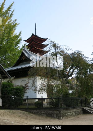 One of the many buildings built on stilts above the water, and connected by decking and boardwalks, that make up Itsukushima Shrine on Miyajima Island Stock Photo