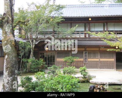 One of the many buildings built on stilts above the water, and connected by decking and boardwalks, that make up Itsukushima Shrine on Miyajima Island Stock Photo