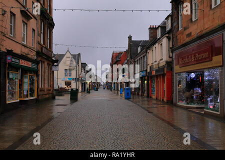 First day after Christmas in Fort William high street in Scotland. Empty street on earlier morning. Pavement still wet after light rain at night. Stock Photo