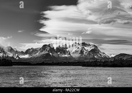 Black and white photograph of the Torres del Paine massif with the Cuernos del Paine in the foreground and a dramatic sky, Patagonia, Chile. Stock Photo