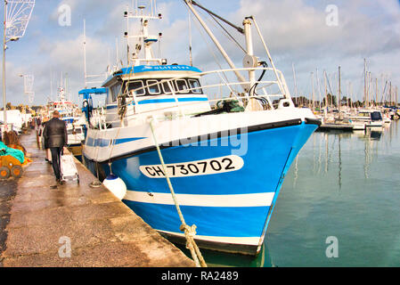 St Vaast, Normandy, France -December circa, 2018. Fishing scallops seafood boat in the harbour with soft warm light at end of afternoon Stock Photo