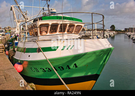 St Vaast, Normandy, France -December circa, 2018. Fishing scallops seafood boat in the harbour with soft warm light at end of afternoon Stock Photo