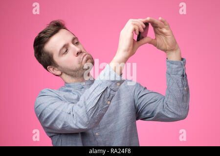 Portrait of a cheerful handsome young man taking selfie on his phone Stock Photo