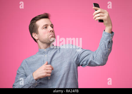 Portrait of a cheerful handsome young man taking selfie on his phone Stock Photo