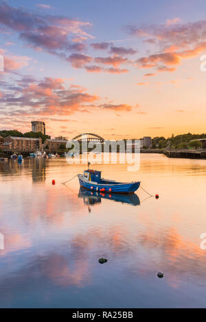 River Wear Fish Quay towards the iconic Wearmouth bridge, fishing boats in foreground, sunset producing a stunning array of colours & reflections Stock Photo