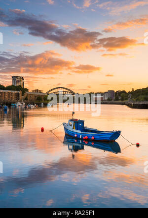 River Wear Fish Quay towards the iconic Wearmouth bridge, fishing boats in foreground, sunset producing a stunning array of colours & reflections Stock Photo