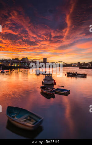 River Wear Fish Quay towards the iconic Wearmouth bridge, fishing boats in foreground, sunset producing a stunning array of colours & reflections Stock Photo