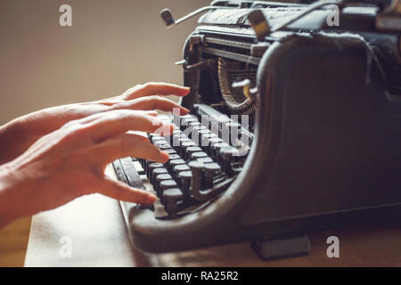 woman hands type on an old vintage dust-covered typewriter Stock Photo