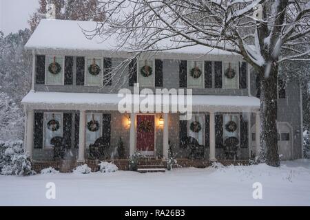 Snow falling on a suburban home decorated for Christmas Stock Photo
