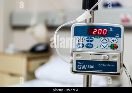 Drip infusion pump in a hospital ward, used to deliver controlled doses of fluids and medicines. Stock Photo