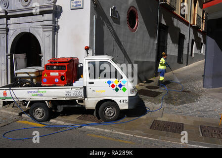 A street cleaner at work with a pressure washer in Granada, Spain. Stock Photo