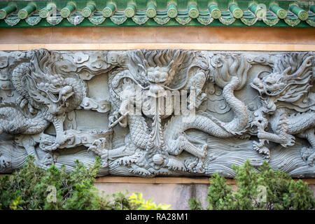 Three of the nine dragons adorning the rear wall of Yau Ma Tei Tin Hau Temple overlooking the Public Square Street Rest Garden in Hong Kong. Stock Photo