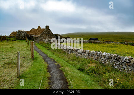 Croft house and pasture with stone walls on the Mainland island of the Shetland Islands of Scotland on a cloudy day Stock Photo