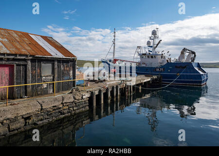 Fishing boat docked in the harbor of Lerwick, Mainland, Shetland Islands, Scotland on a bright sunny day Stock Photo