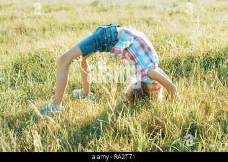 Happy little girl doing a handstand on the beach at Pilat dune, France ...