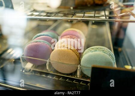 Fresh colored macaroons close-up, sale in coffee shop showcase. Stock Photo