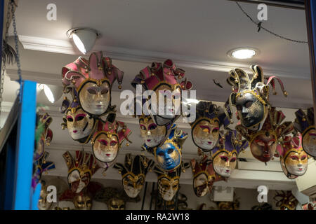 The masks of the Venice carnival hung in a shop. Venetian masks representing the carnival. Stock Photo