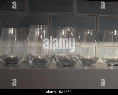 Shelf with close up of small wine glasses in gray kitchen Stock Photo