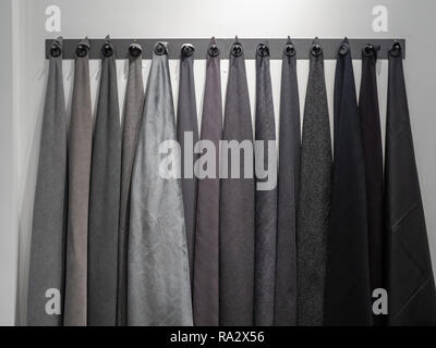 Wall rack with dark shades of gray and black materials of sample fabrics Stock Photo