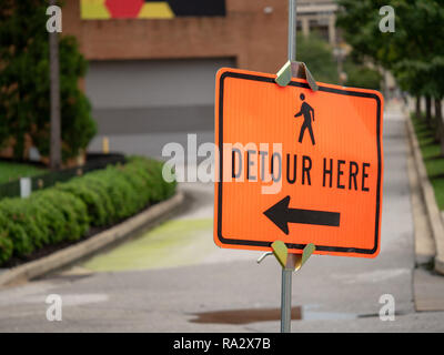 Detour here sign with person walking symbol and arrow pointing left Stock Photo