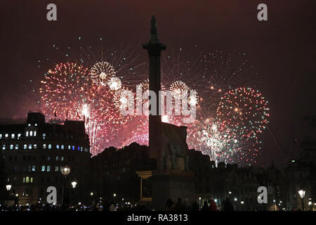 London, UK. 1st January 2019. New Years Eve Fireworks seen from Trafalgar Square in London with Nelson's Column silhouetted against the fireworks Credit: Paul Brown/Alamy Live News Stock Photo