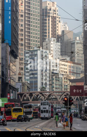 Buildings stacked one on top of another almost overwhelm the people at street level in one of Hong Kong's most crowed districts. Stock Photo