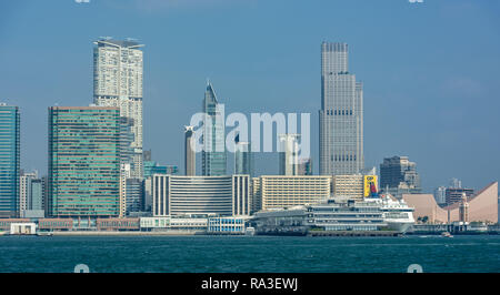 The towers of Tsim Sha Tsui dominate the skyline above Victoria Harbour the Cultural Centre and Ocean terminal. Stock Photo